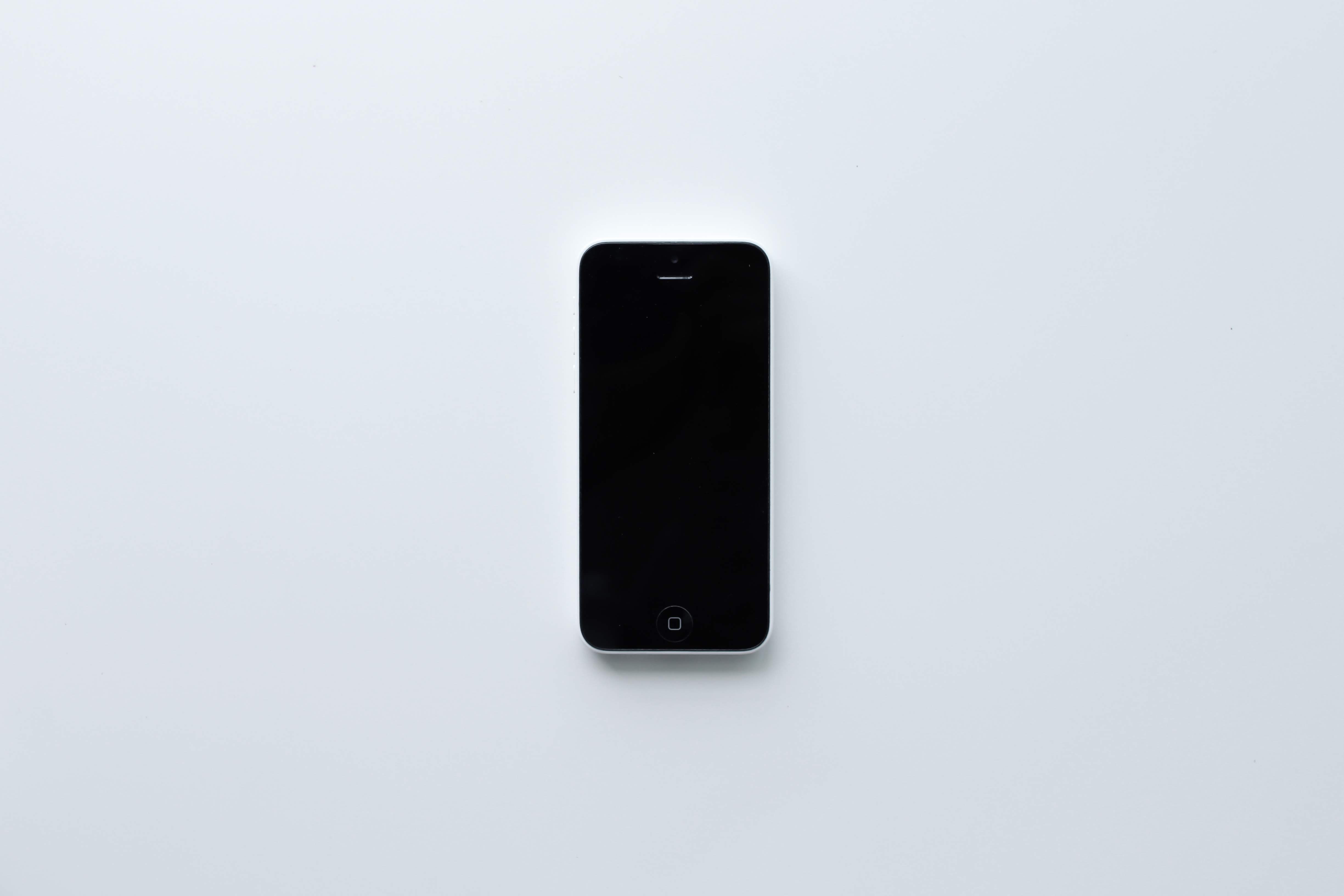 黒い画面を見せる白い iPhone 5c