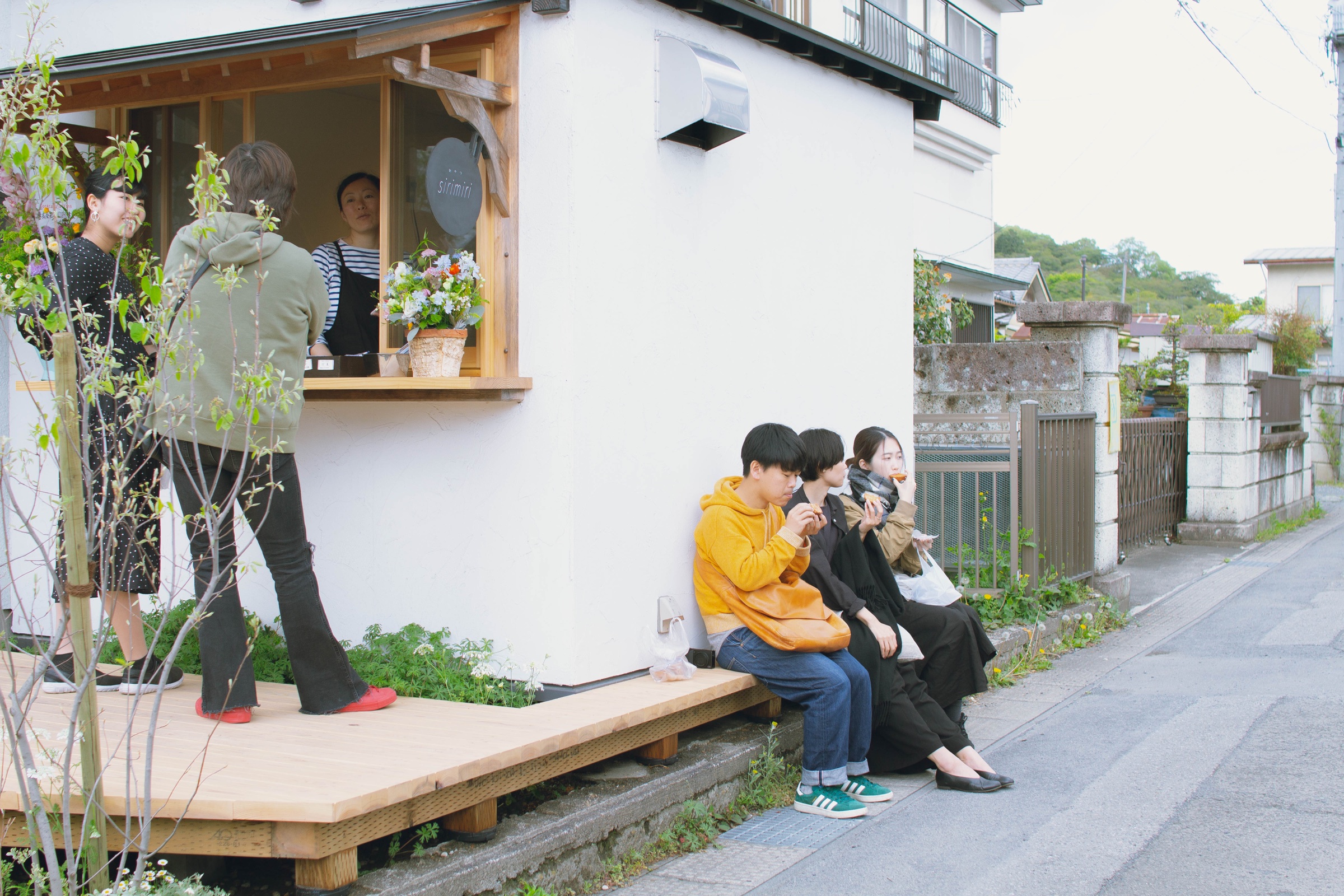 道路から見たおやつsirimiriと店先のデッキ